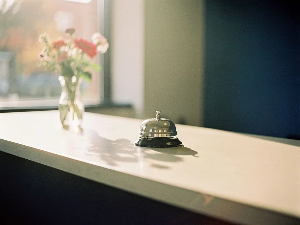 Empty customer reception counter with a small bell and fresh flowers